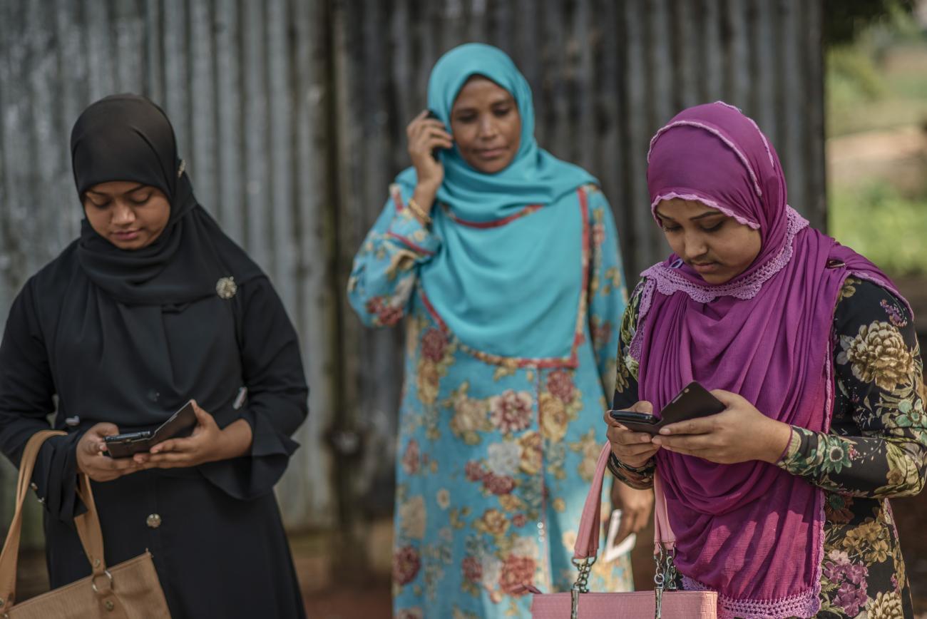 In Rajbari, Nilima (far right) checked on her mobile money account after a visit to the bKash agent. Her friend Farzana (left) came with her to open an account, accompanied by Nilima's mother.